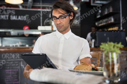 Preview: Man in coffee shop using digital tablet