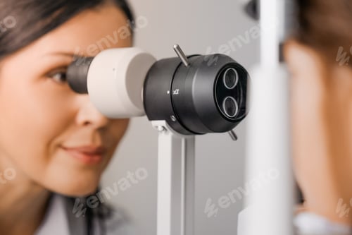 Preview: Doctor ophthalmologist doing slit lamp examination of cute boy in modern clinic