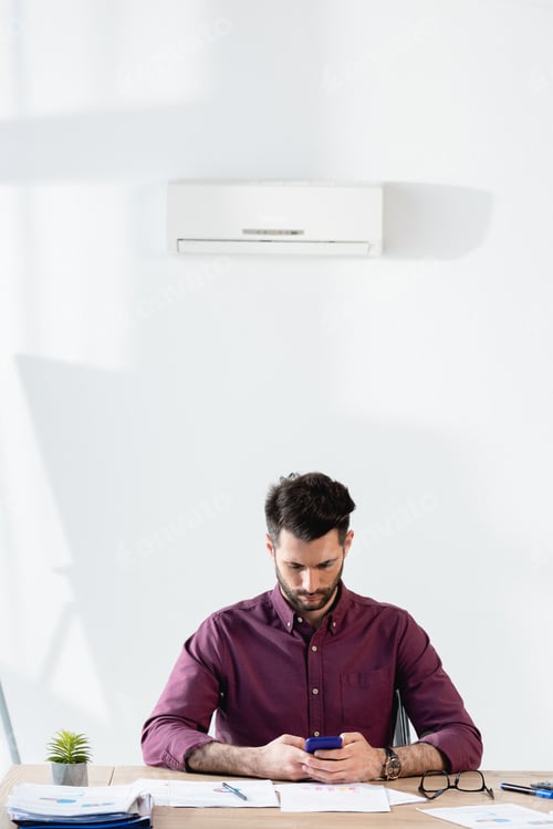 Preview: Man Works with Phone at Bright Desk