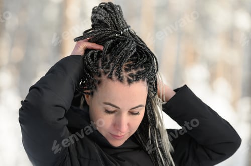 Preview: Young woman with African braids in natural winter environment landscape