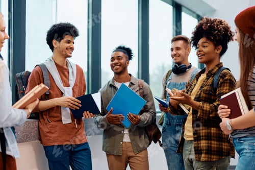 Preview: Happy students communicating after a lecture in hallway at the university.