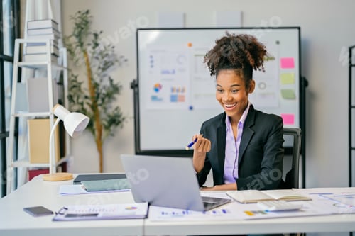 Preview: Happy african american businesswoman attending a video conference in modern office