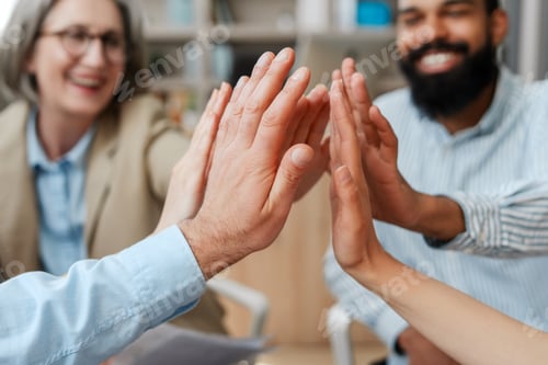Preview: Business people team giving high five together in modern office selective focus