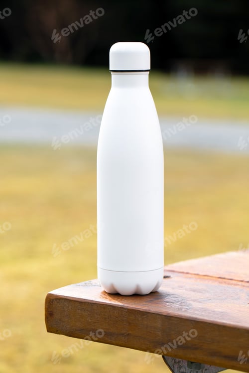 Preview: Blank thermos on wooden table at countryside closeup