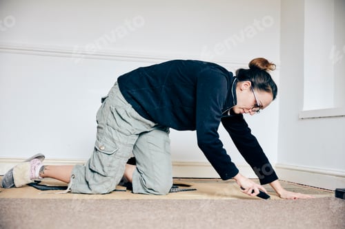 Preview: Woman using knife to cut away carpet on floor