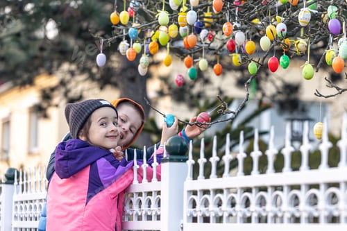 Preview: Little children and a tree decorated with many decorative Easter eggs.
