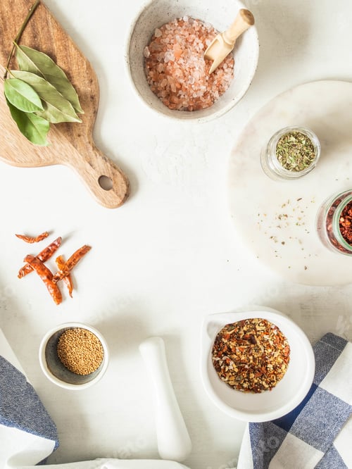 Preview: Various dry spices and dry vegetables in mortar and glass jars flat lay on kitchen table