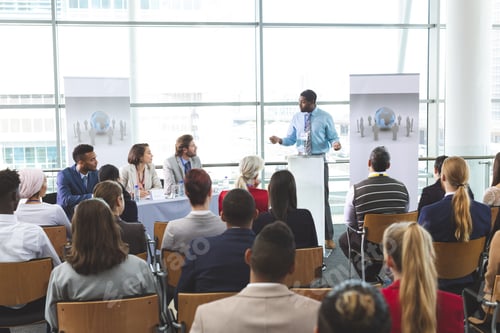 Preview: Businessman speaker speaking in business seminar in modern office building