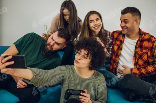 Preview: Friends having fun at home and taking selfie with a smartphone