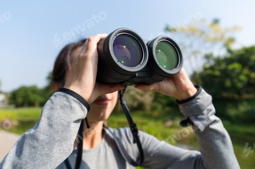 Preview: Asian Woman looking though binoculars