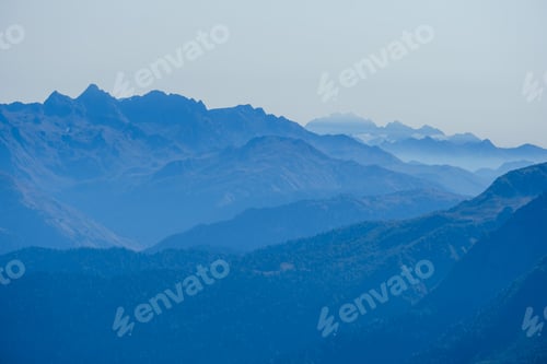 Preview: blurred abstract natural background with Caucasus Mountains in a morning blue mist