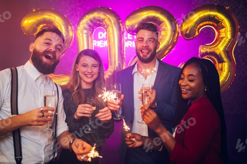 Preview: Multiracial friends celebrating new years eve with champagne and sparklers