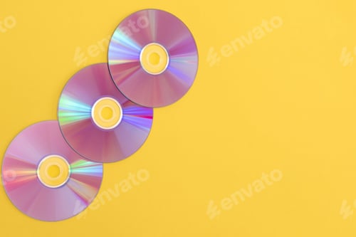 Preview: Three colourful compact discs on a yellow background