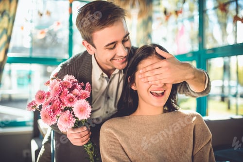 Preview: The happy man make a surprise with flowers for a woman in the restaurant