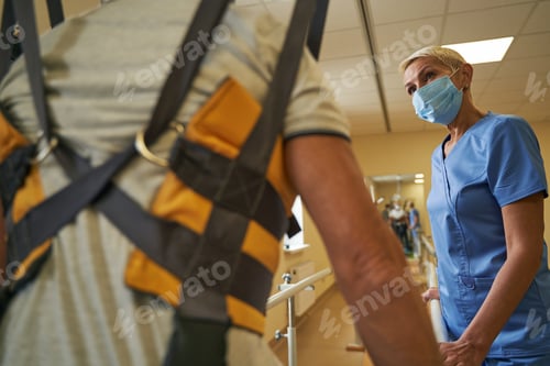 Preview: Physical therapist helping stroke patient in rehab center