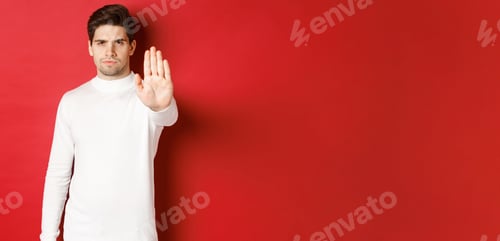 Preview: Image of serious and confident man telling to stop, forbid something, extending one hand and