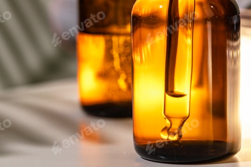 Preview: Brown glass bottles with oily skincare serum close up