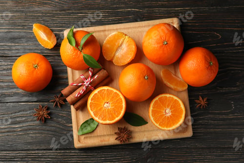 Preview: Board with mandarins and cinnamon on wooden background