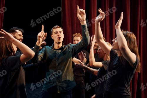 Preview: Group of actors in dark colored clothes on rehearsal in the theater