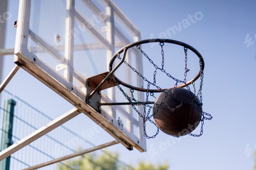 Preview: a sports ground basketball field shot from below basketball hoop with chains hitting the target