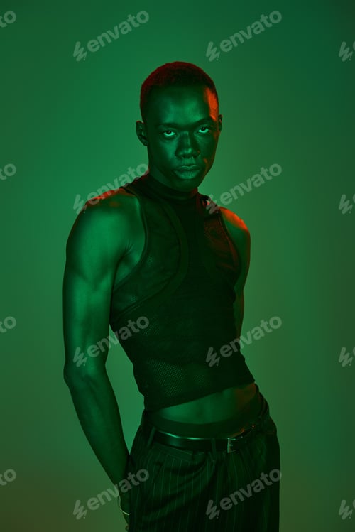 Preview: Vibrant young african american man showcasing unique fashion in an artistic light