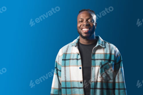 Preview: Handsome black man smiling. Mid shot. Blue background
