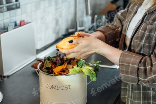 Preview: Compost kitchen waste, recycling at home. Woman putting vegetables cutted leftovers into compost bin