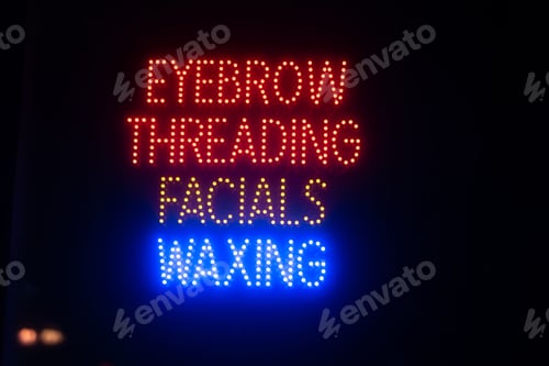 Preview: Row of illuminated neon signs on the side of a busy street
