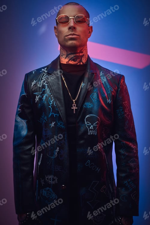 Preview: Fashionable tattooed male model posing in a studio