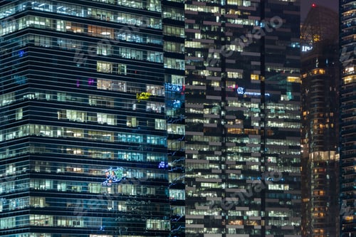 Preview: Pattern of office buildings windows illuminated at night. Lighting with Glass architecture facade