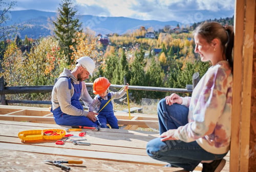 Preview: Father, mother and son building wooden frame house.