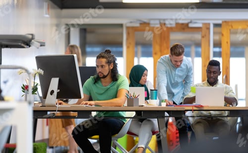 Preview: Front view of diverse business people working at desk in a modern office