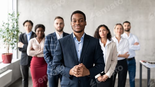 Preview: Successful African Businessman Standing With His Business Team In Office
