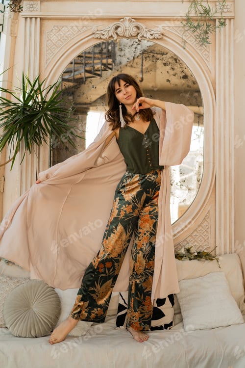 Preview: Beautiful woman in elegant wome wear posing in stylish bohemian interior.