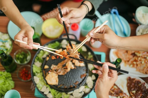 Preview: People Holding Chopsticks with Beef Together at Barbecue Party