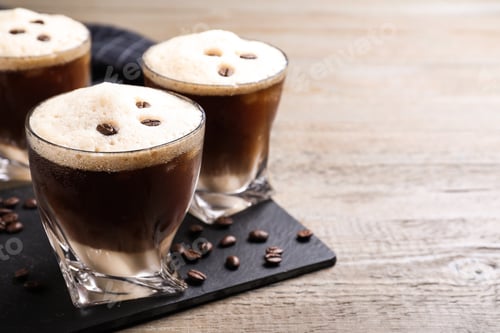 Preview: Glasses of tasty cocktail with coffee beans on wooden table, closeup