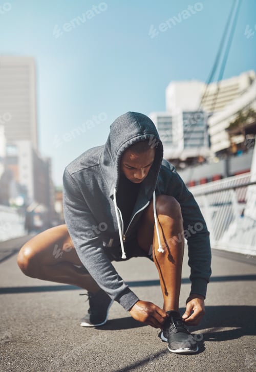 Preview: Lace up. Shot of a sporty young man tying his laces before a run.
