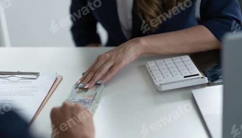 Preview: Close up of businessman hand giving money, cash dollars banknotes, to his partner on the table -