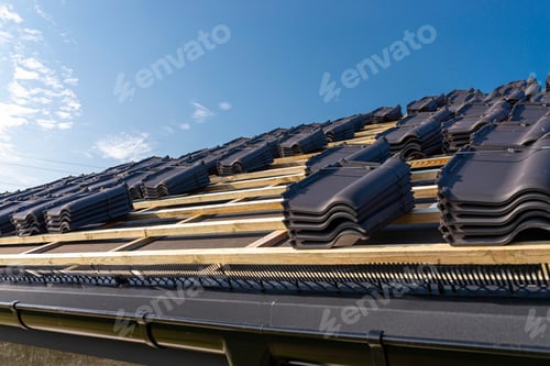 Preview: Roof ceramic tile arranged in packets on the roof on roof battens. Preparation for laying roof tiles