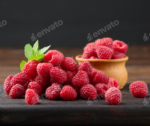 Vista previa: Ripe red raspberries on a brown wooden board