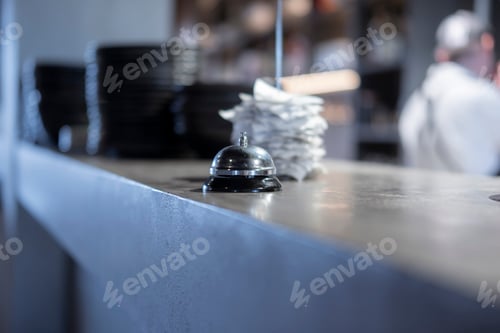 Preview: Service Bell on the Counter at a Bustling Restaurant During Peak Hours
