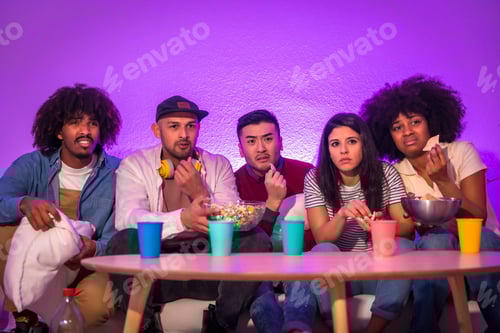 Preview: Group of multiracial friends watching a movie and having popcorn together