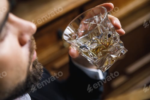 Preview: Man with a glass of expensive whiskey