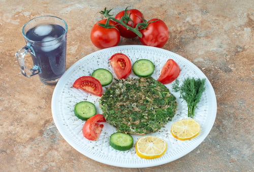 Preview: A white plate with vegetables and cup of juice