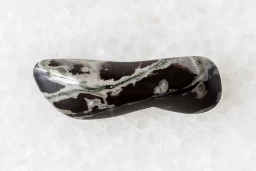 Preview: sample of tumbled hornfels mineral on white marble