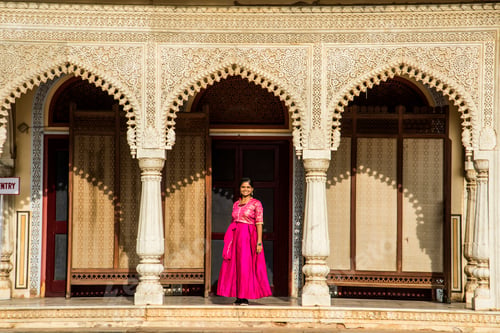 Preview: Indian young woman in front of old colorful door.