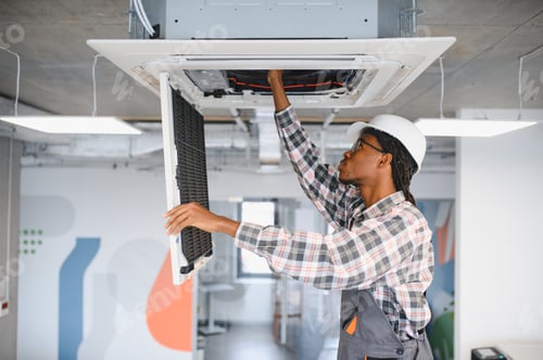 Preview: African American Technician repairing air conditioning filter in office building