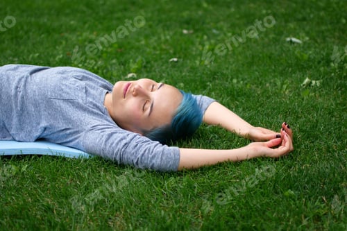 Preview: Woman lying on the grass in the park