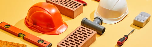Preview: panoramic shot of bricks, helmets, spirit level, pipe connector, folding ruler, and screwdriver on