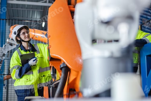 Preview: Female engineer using tablet checking system robot arm automate.